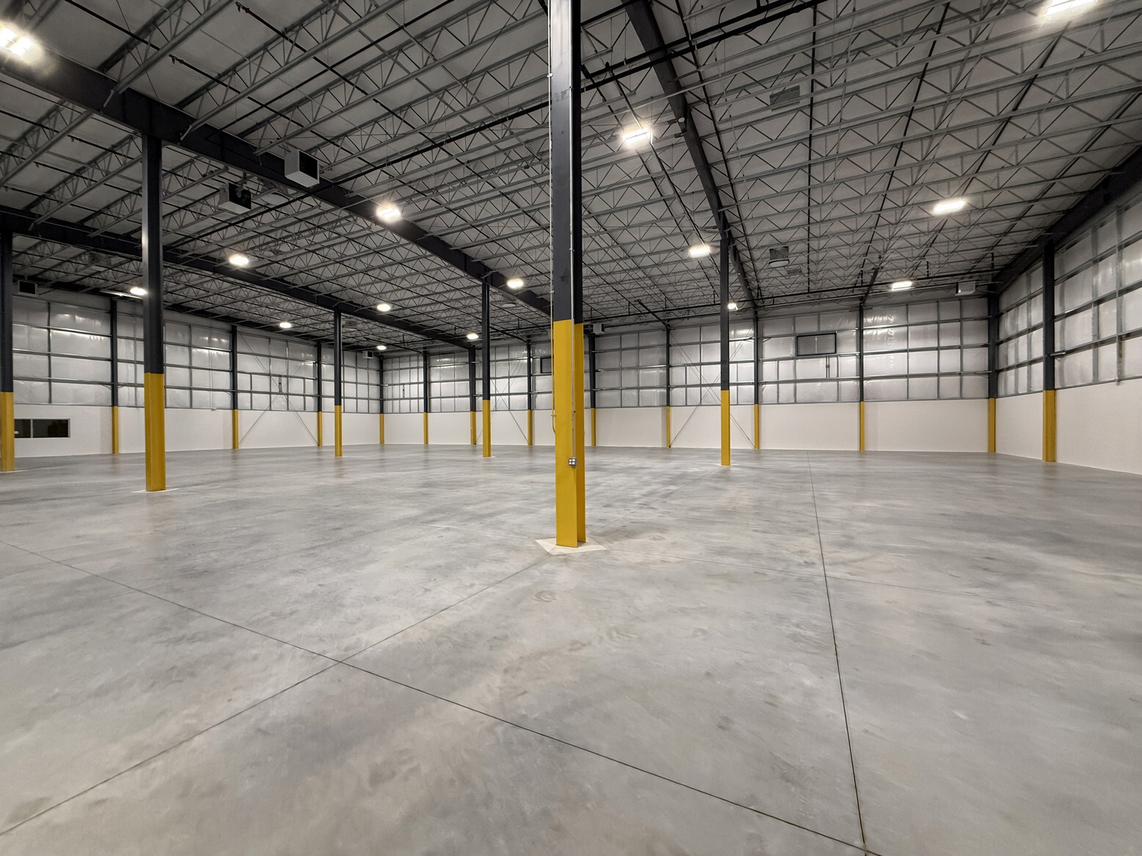 Spacious warehouse interior with polished concrete floor and steel ceiling trusses